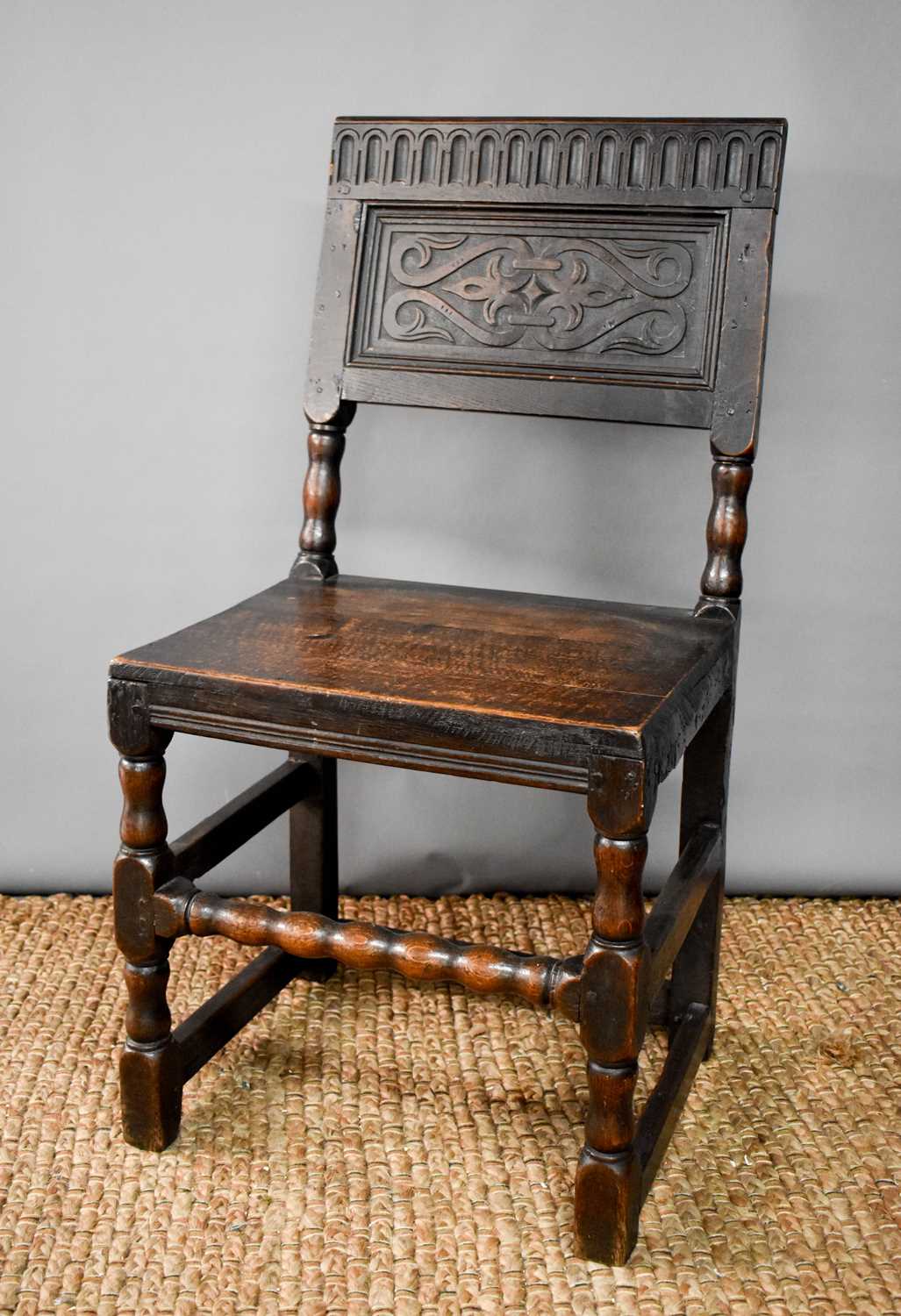 Lot 523 - An 18th century oak chair, the back panel...