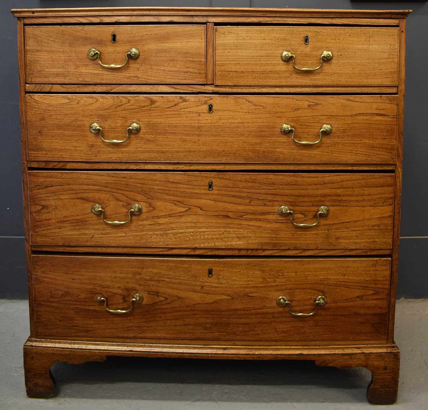 Lot 504 - A Georgian elm chest of drawers, the two short...