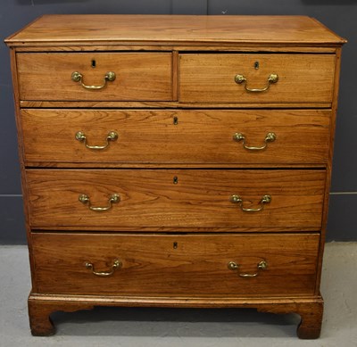 Lot 504 - A Georgian elm chest of drawers, the two short...