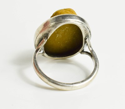 Lot 37 - A white metal ring, with relief moulded stone...