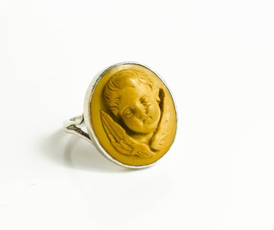 Lot 37 - A white metal ring, with relief moulded stone...