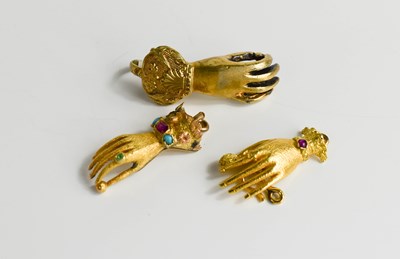 Lot 54 - Two gold hand form clasps, set with gemstones...