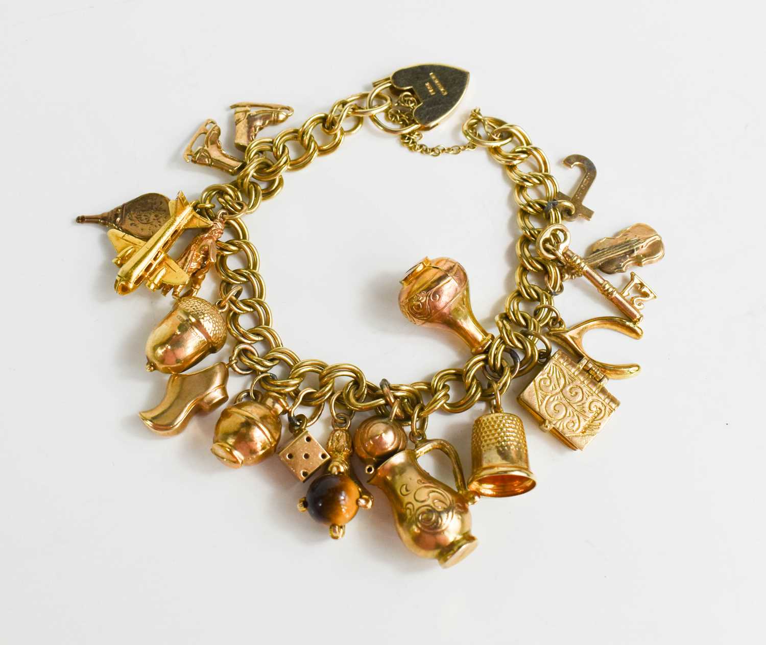 Lot 169 - A 9ct gold charm bracelet with nineteen charms,...