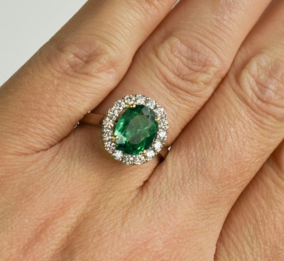 Lot 171 - An oval emerald, platinum and diamond cluster...