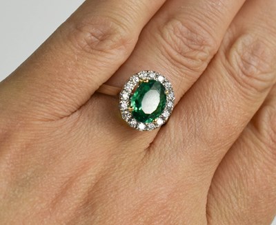 Lot 171 - An oval emerald, platinum and diamond cluster...