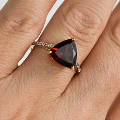 Lot 103 - A 9ct gold and garnet ring, triangle cut...