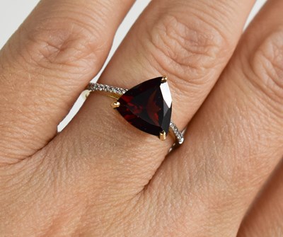 Lot 103 - A 9ct gold and garnet ring, triangle cut...