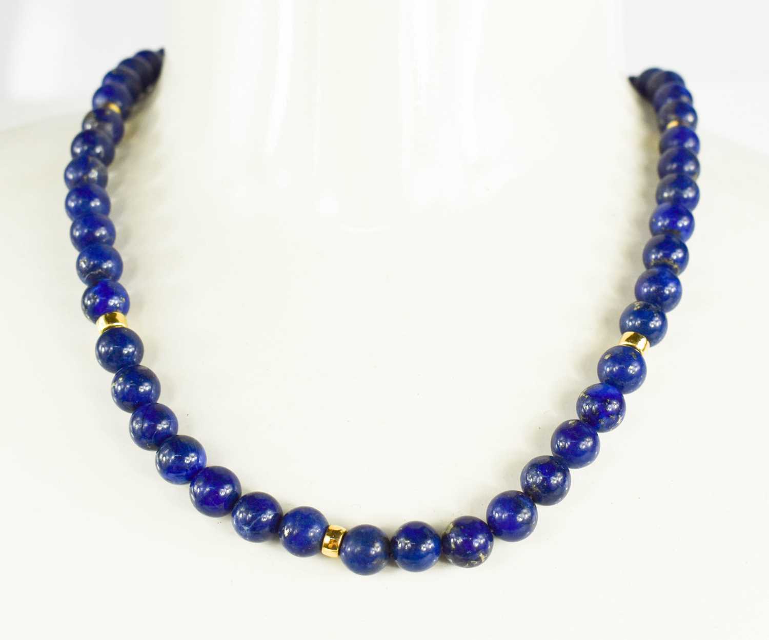 Lot 26 - An 18ct gold and lapiz lazuli beaded necklace,...
