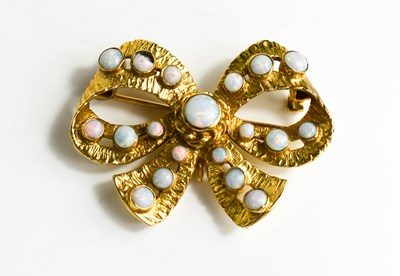 Lot 206 - A 9ct gold and opal bow brooch, set with 19...