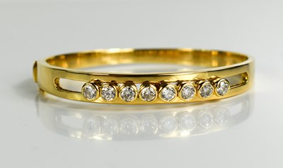 Lot 17 - An 18ct gold and diamond bangle, set with...