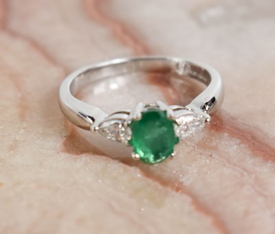 Lot 225 - An 18ct white gold, oval emerald and pear...