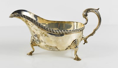 Lot 110 - A silver sauce boat, raised on three stepped...