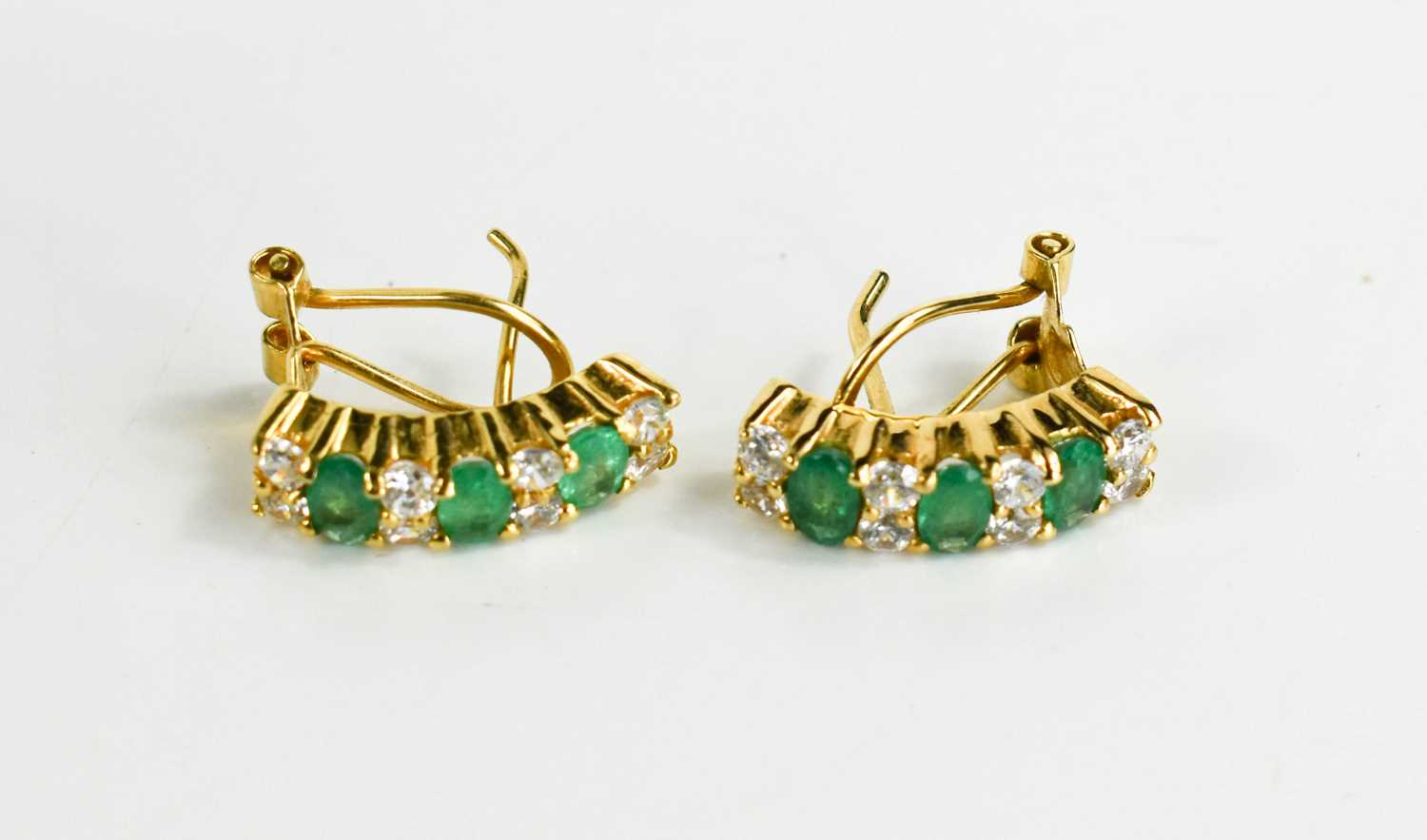 Lot 143 - A pair of 18ct gold, emerald and white stone...