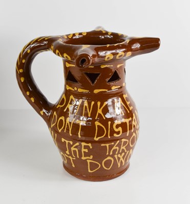 Lot 172 - A terracotta slipware glazed puzzle jug, with...